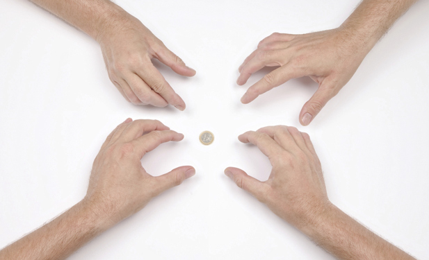 Four hands reaching for coin