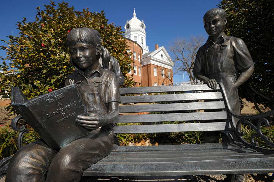 A bronze statue of a young girl reading “To Kill a Mockingbird,” in Monroeville, Alabama. Photograph by G. M. Andrews