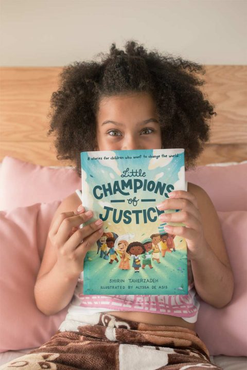 Little girl reading Little Champions of Justice.