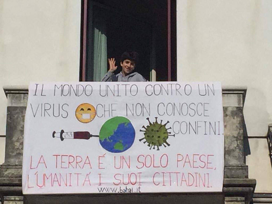 A family in Italy hung an encouraging sign with words from Baha’u’llah out their window. It reads: ’the world united against a virus that knows no borders. "the earth is but one country and mankind its citizens"’