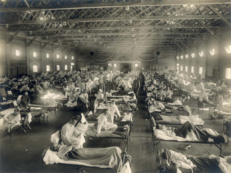 Beds with patients in an emergency hospital in Kansas, in the midst of the Spanish flu epidemic. The flu struck while America was at war, and was transported across the Atlantic on troop ships (1918).