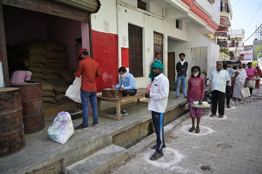 People maintain social distance as they in queue to receive free ration during lockdown in wake of Coronavirus pandemic in Prayagraj on Thursday, April 02, 2020.