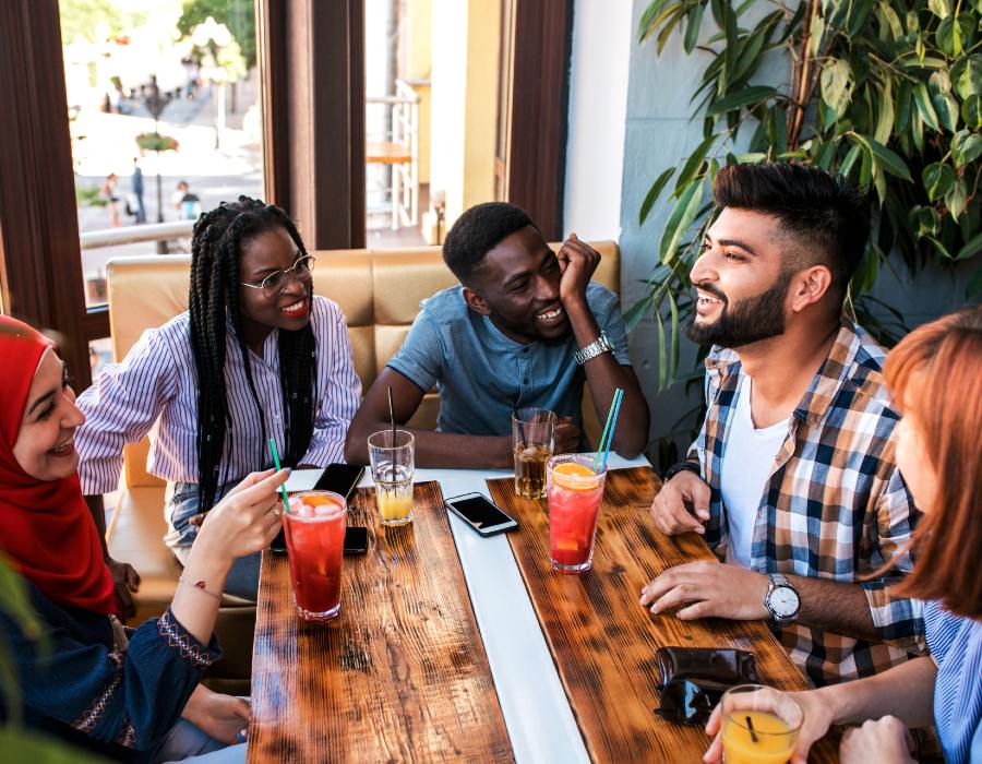 Diverse group chatting and smiling at a cafe