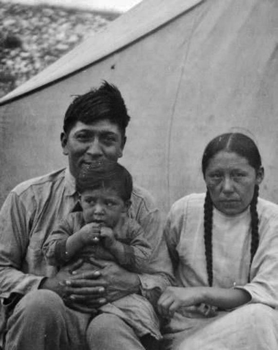 John Stands in Timber (L) with his wife and son (1926).