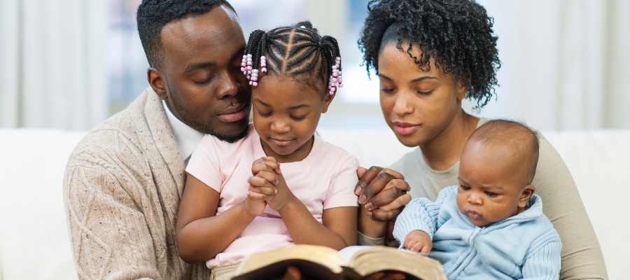 children praying with parents