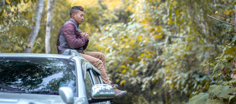 man praying on car while he is traveling