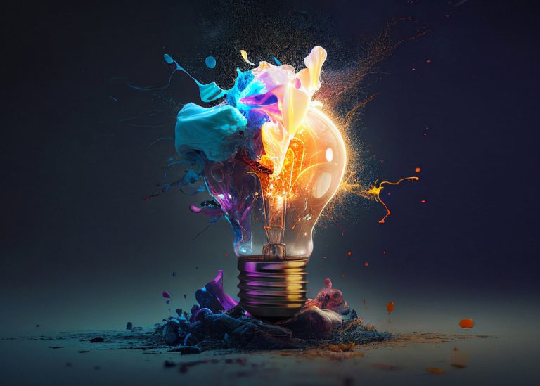 Creative light bulb explodes with colorful paint and splashes on a black background.