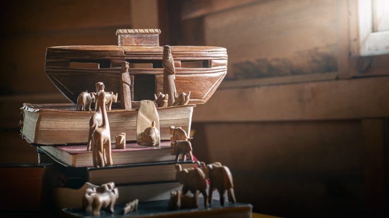 Story of Noah's Ark adventure with animals in the Bible and History books, wooden carved doll, Christian concept.