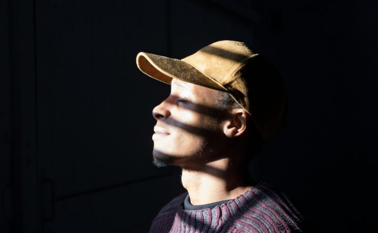 A man smiling as sunlight illuminates his face, symbolizing the pursuit of spirituality.